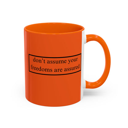 don't assume your freedoms are assured Black font Orange Accent Mug by theGreenDragonTavern.shop