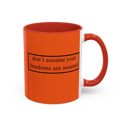 don't assume your freedoms are assured Black font Orange Accent Mug by theGreenDragonTavern.shop